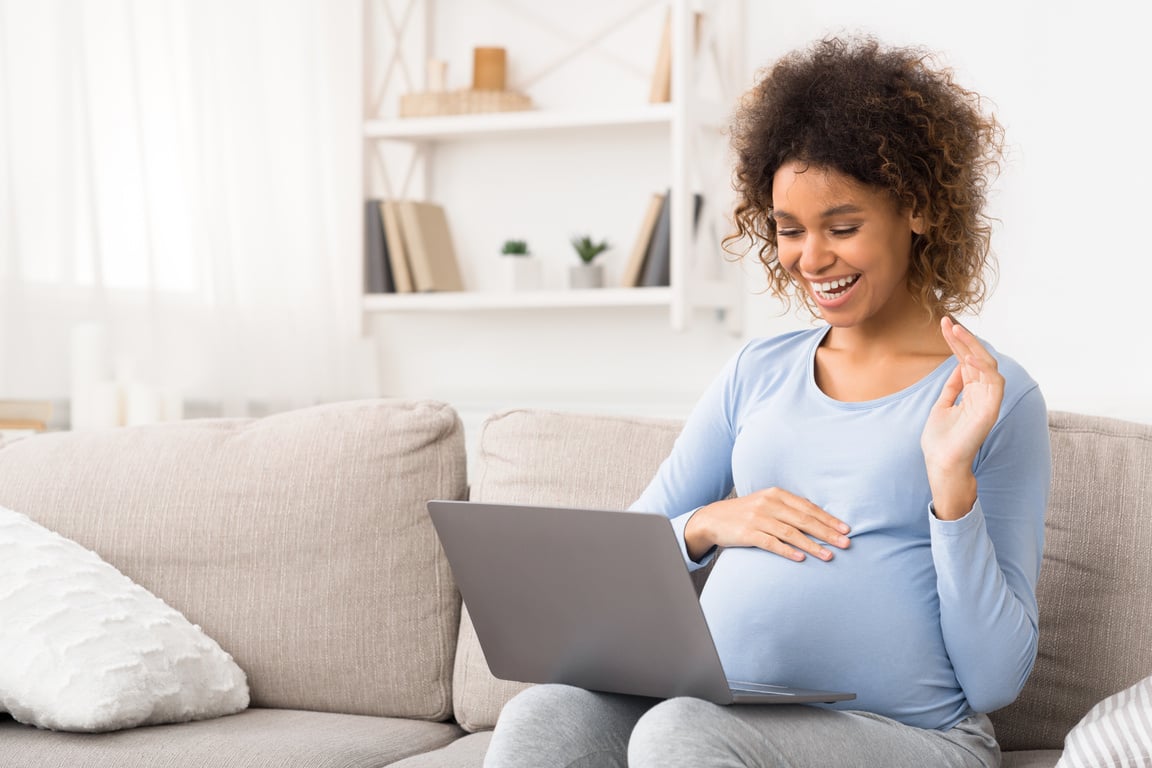 Pregnant Woman Video Calling on Laptop in the Living Room